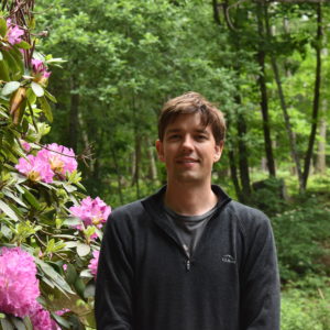 Garrett Bent outside next to Rhododendron